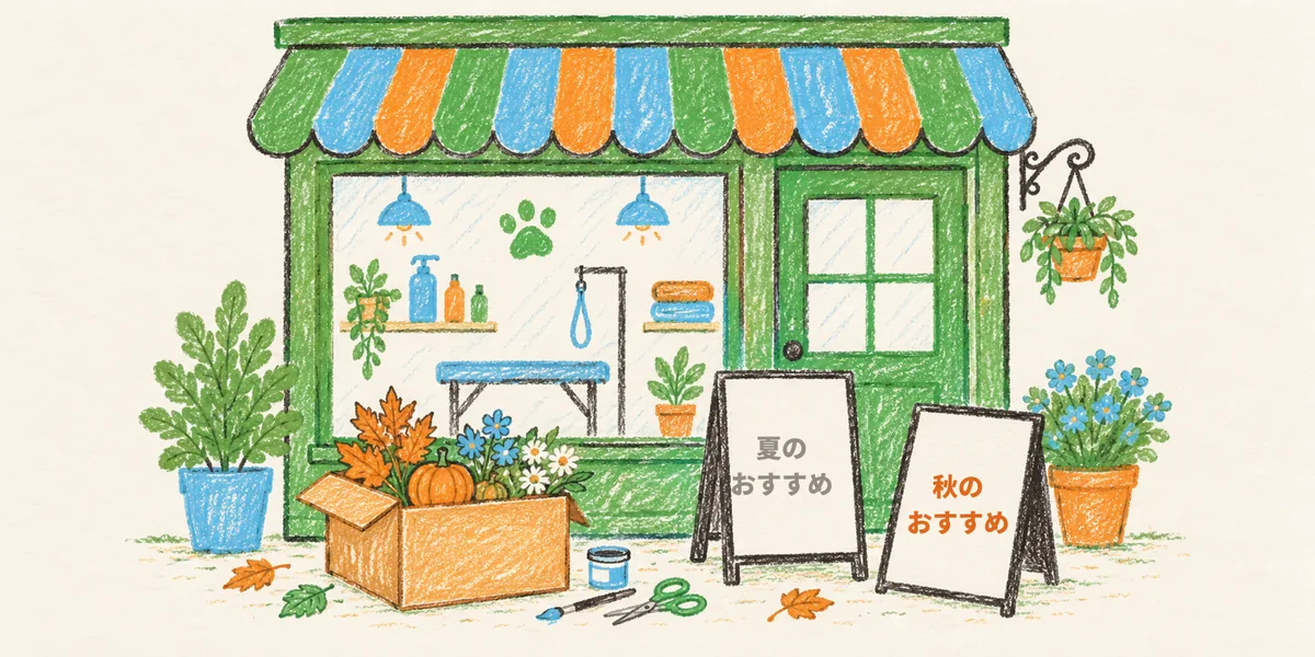 ペットサロンの店先で、季節の飾りが入った箱の横に「夏のおすすめ」の札と、新しい「秋のおすすめ」の札が並んでいる絵