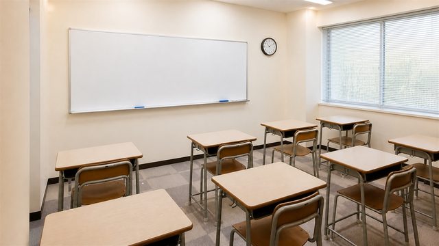 中学生向けの机が並ぶ明るい塾の教室